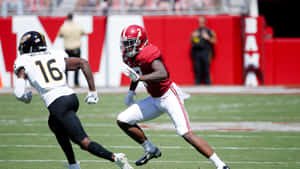 A Football Player Running With The Ball Wallpaper