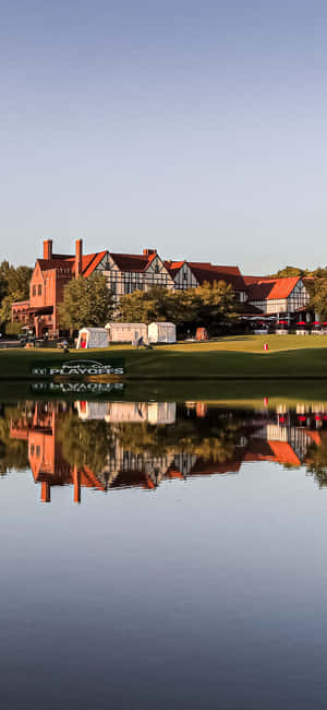 A Golf Course With A House Reflected In The Water Wallpaper