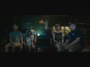 A Group Of Children Are Sitting In A Dark Room Wallpaper