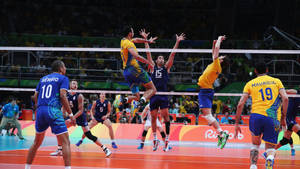 A Group Of Men Playing Volleyball In A Game Wallpaper