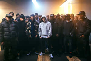 A Group Of Men Standing In Front Of A Light Wallpaper