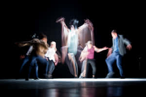 A Group Of People Dancing On Stage Wallpaper