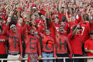 A Group Of People In Red And White With The Word Tech Painted On Their Faces Wallpaper