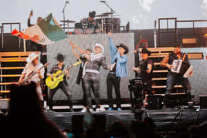 A Group Of People On Stage With A Mexican Flag Wallpaper