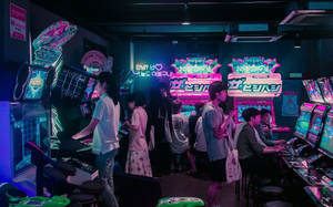 A Group Of People Playing Video Games In A Room Wallpaper