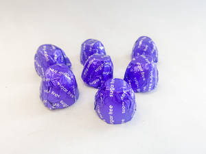 A Group Of Purple Chocolates On A White Surface Wallpaper