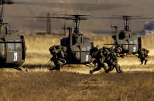 A Group Of Soldiers Running Through A Field Wallpaper