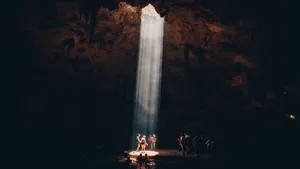 A Group Of Tourists Exploring An Impressive Natural Cave Wallpaper