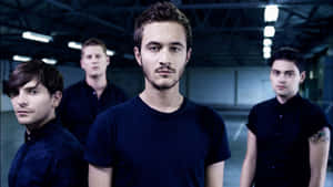 A Group Of Young Men Standing In A Dark Room Wallpaper