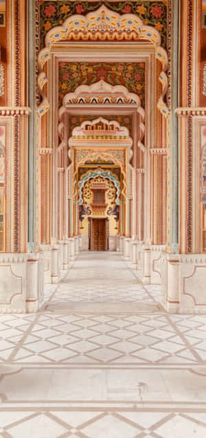 A Hallway In An Ornate Building With White Walls Wallpaper