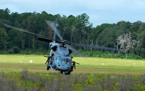 A Helicopter Is Flying Over A Field Wallpaper