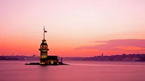 A Lighthouse Is Floating In The Water At Sunset Wallpaper