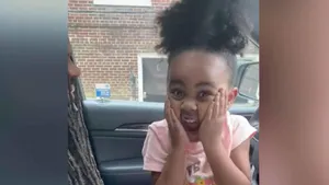 A Little Girl Is Laughing While Sitting In The Car Wallpaper