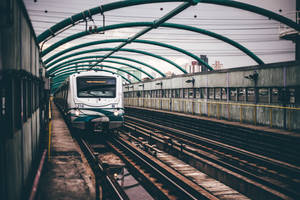 A Lonely White Train Pauses At A Gloomy Station On A Drizzly Day Wallpaper