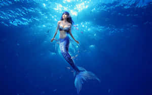 A Magnificent Mermaid Swimming Gracefully Through A Pool Of Shimmering Water. Wallpaper