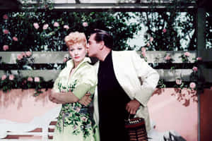 A Man And Woman Kissing In Front Of A Flower Garden Wallpaper