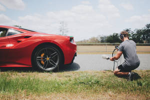 A Man Driving A Red Ferrari Wallpaper