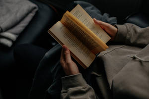 A Man Enjoys Reading A Book Wallpaper