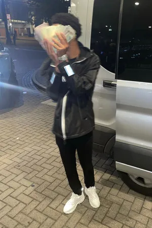 A Man Holding A Phone While Standing Next To A Van Wallpaper