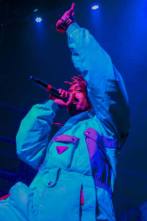 A Man In A Blue Suit Is Holding A Microphone Wallpaper