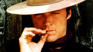 A Man In A Cowboy Hat Smoking A Cigarette Wallpaper