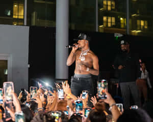 A Man In A Shirt Is Standing In Front Of A Crowd Wallpaper