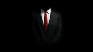 A Man In A Suit And Tie Is Standing In The Dark Wallpaper