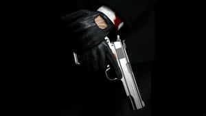 A Man In A Suit Holding A Gun Wallpaper