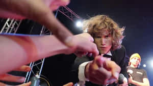 A Man In A Suit Is Pointing To A Crowd Wallpaper