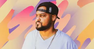 A Man In A White Shirt And Hat Is Standing In Front Of A Colorful Background Wallpaper