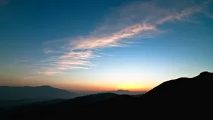 A Man Is Standing On Top Of A Mountain At Sunset Wallpaper