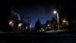 A Man Is Walking Down A Street At Night Wallpaper