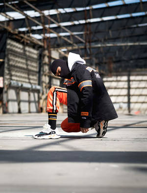 A Man Kneeling Down In An Industrial Building Wallpaper