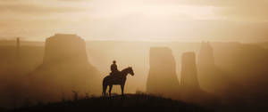 A Man On A Horse Is Standing On A Hill Wallpaper