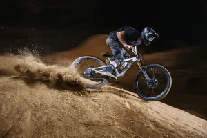 A Man Riding A Mountain Bike On A Dirt Hill Wallpaper