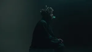 A Man Sitting On A Box In The Dark Wallpaper