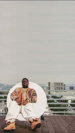 A Man Sitting On A Chair Wallpaper