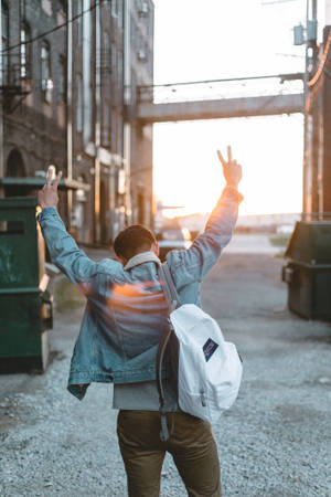 A Man Wearing A Guy Fawkes Mask And Standing With A Backpack Near A Graffiti. Wallpaper