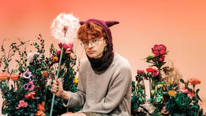 A Man With Red Hair Sitting On A Flower Bed Wallpaper