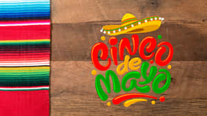 A Mexican Hat And A Mexican Blanket On A Wooden Table Wallpaper