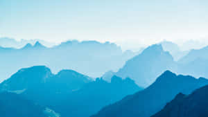 A Mountain Range With A Blue Sky Wallpaper