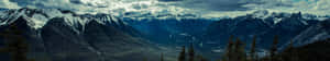 A Mountain Range With Clouds And Snow Wallpaper