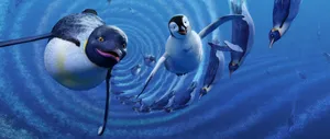 A Penguin Is Swimming In The Ocean With Other Penguins Wallpaper