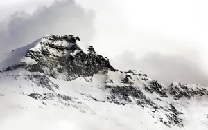 A Person Is Skiing Down A Snow Covered Mountain Wallpaper