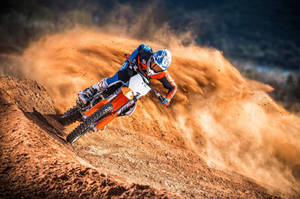 A Person Riding A Dirt Bike On A Dirt Track Wallpaper