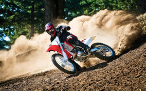 A Person Riding A Dirt Bike On A Dirt Trail Wallpaper