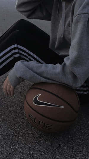 A Person Sitting On The Ground With A Basketball Ball Wallpaper