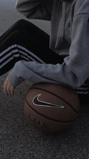A Person Sitting On The Ground With A Basketball Ball Wallpaper