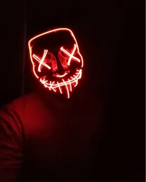 A Person Wearing A Red Led Mask In The Dark Wallpaper