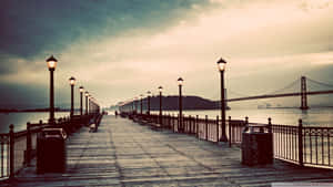 A Pier With A Bridge And Lights On It Wallpaper